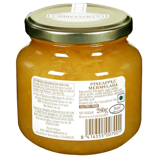 Jar of pineapple marmalade with a gold lid on a white background