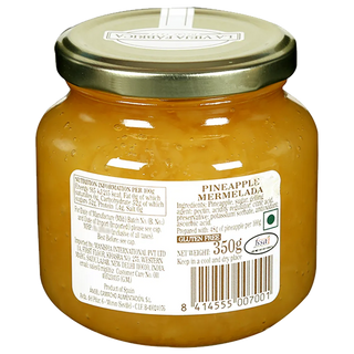 Jar of pineapple marmalade with a gold lid on a white background